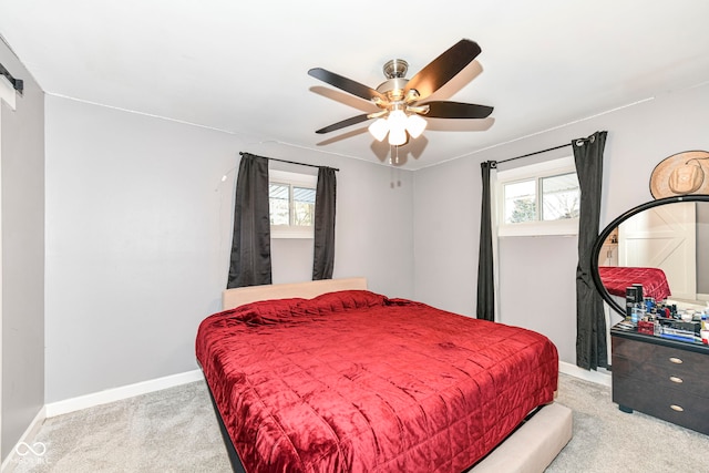 carpeted bedroom featuring multiple windows and ceiling fan