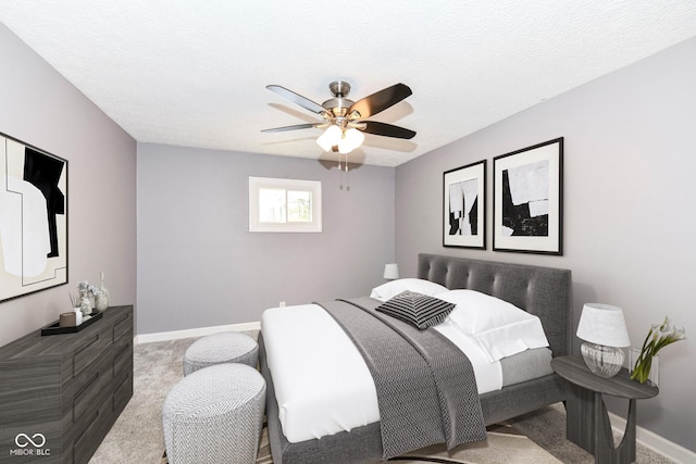 bedroom featuring light carpet, a textured ceiling, and ceiling fan