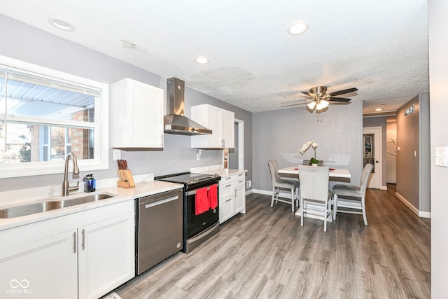 kitchen with sink, appliances with stainless steel finishes, range hood, a textured ceiling, and white cabinets