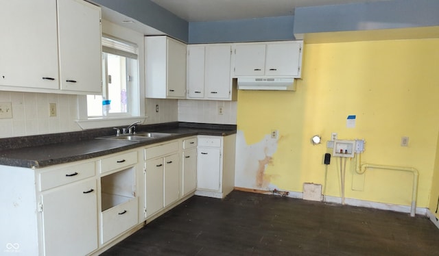 kitchen with decorative backsplash, dark wood-type flooring, sink, and white cabinetry