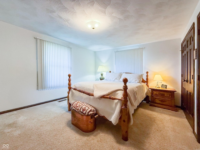 bedroom featuring a textured ceiling and light carpet