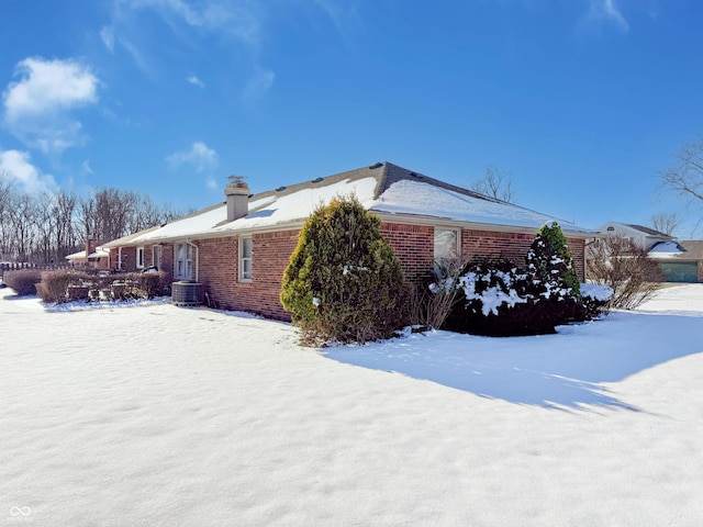 snow covered property featuring central AC