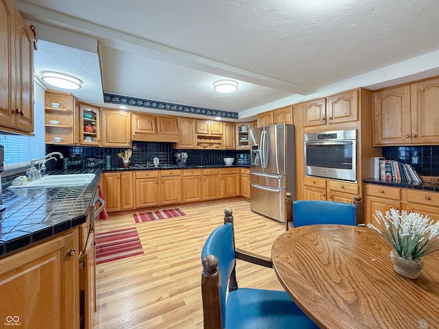 kitchen featuring sink, stainless steel appliances, a textured ceiling, and backsplash