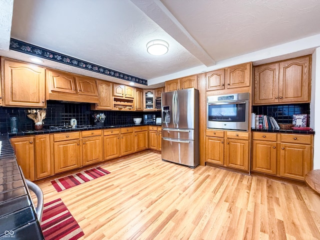 kitchen featuring backsplash, light wood-type flooring, and stainless steel appliances