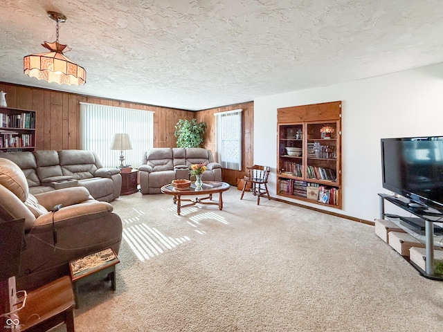 carpeted living room with wood walls and a textured ceiling