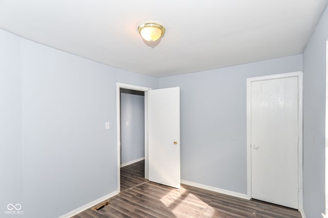 unfurnished bedroom featuring dark hardwood / wood-style flooring