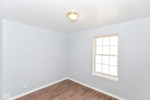 unfurnished room with dark hardwood / wood-style flooring