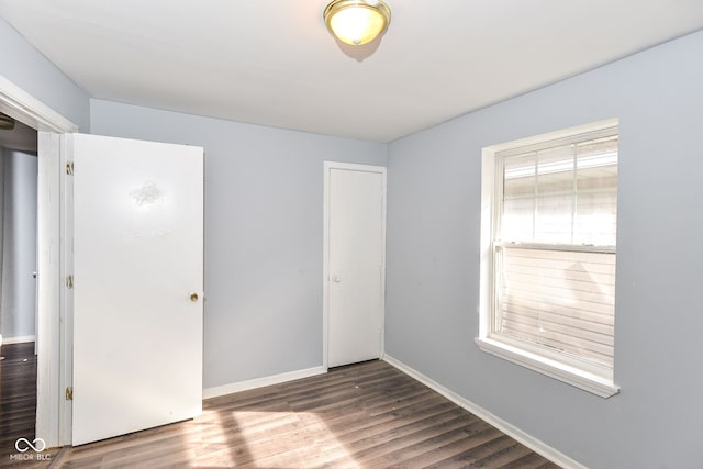 unfurnished bedroom featuring dark hardwood / wood-style flooring and a closet