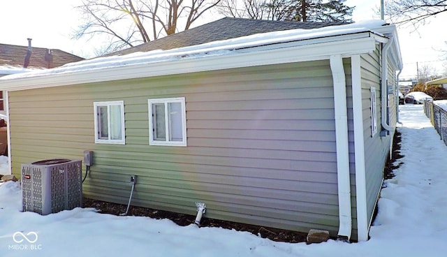 view of snowy exterior featuring central air condition unit