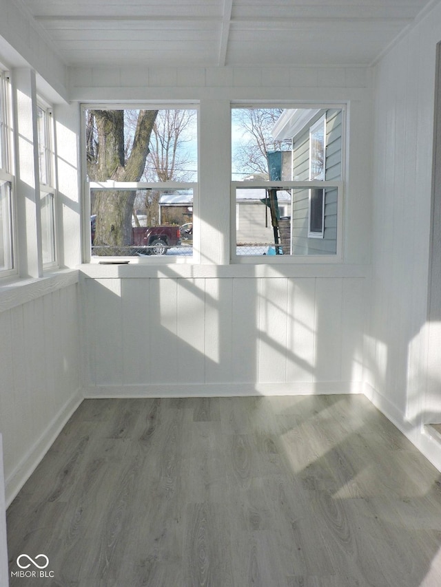 unfurnished sunroom with beamed ceiling