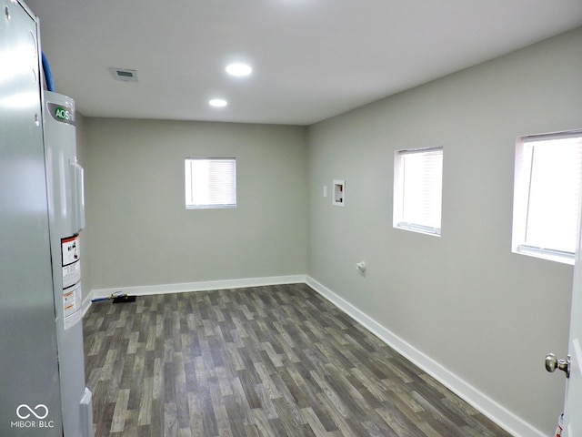 clothes washing area featuring hookup for a washing machine, plenty of natural light, dark hardwood / wood-style flooring, and water heater