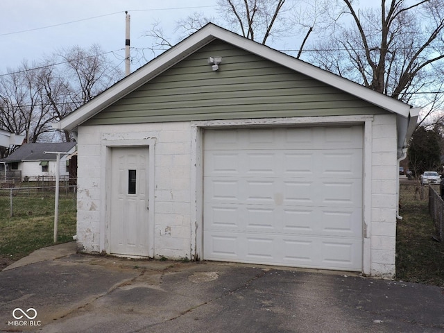 detached garage with aphalt driveway and fence