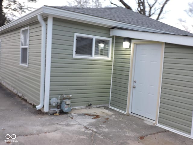 exterior space featuring roof with shingles