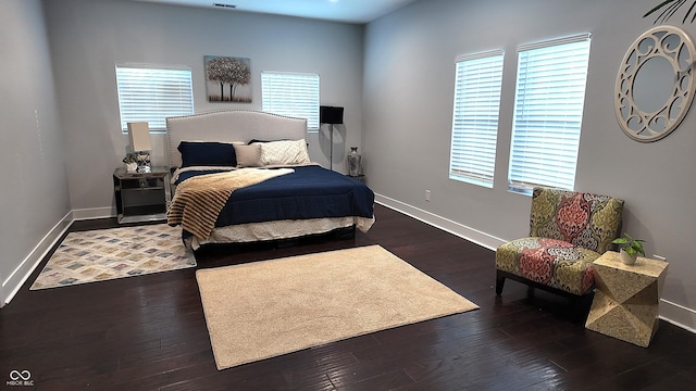 bedroom with dark wood-type flooring and multiple windows