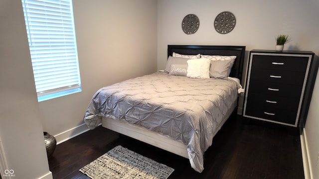 bedroom with dark hardwood / wood-style flooring