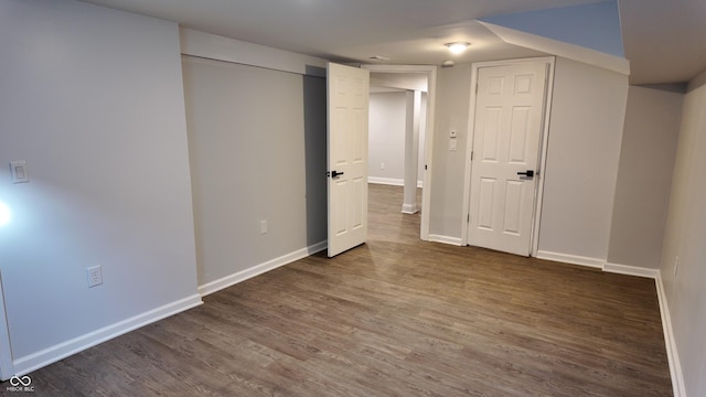 basement with dark hardwood / wood-style floors