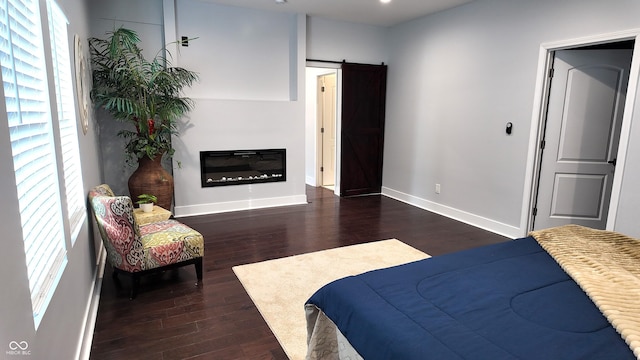 bedroom featuring dark wood-type flooring and a barn door