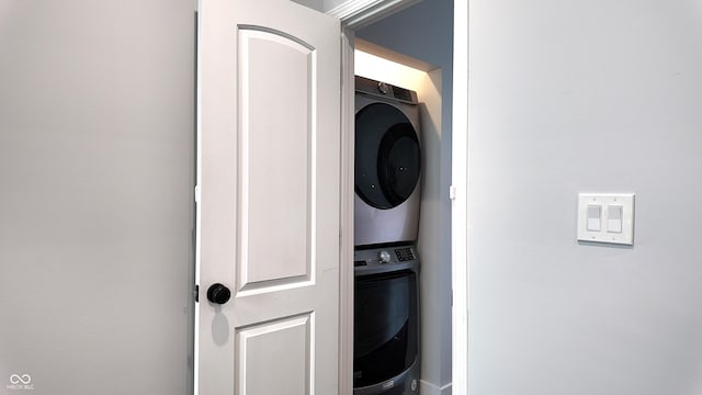 washroom featuring stacked washer and clothes dryer