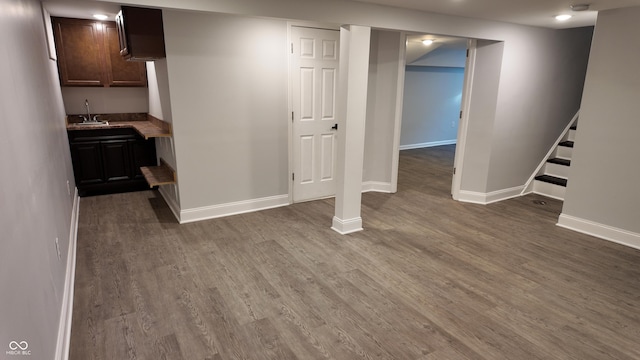 basement featuring wet bar and dark hardwood / wood-style flooring