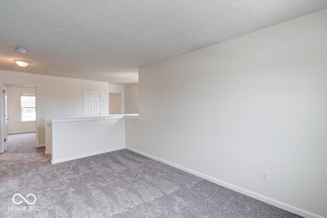 carpeted spare room featuring a textured ceiling