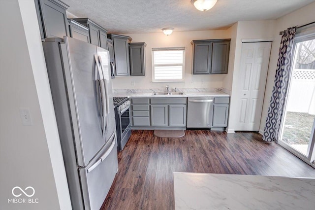 kitchen featuring gray cabinets, sink, dark hardwood / wood-style flooring, stainless steel appliances, and a textured ceiling