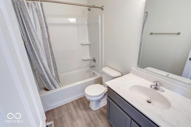 full bathroom featuring vanity, hardwood / wood-style floors, shower / tub combo with curtain, and toilet