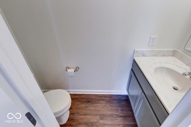 bathroom with hardwood / wood-style flooring, vanity, and toilet