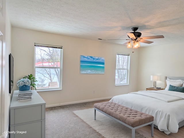 carpeted bedroom with a textured ceiling and ceiling fan