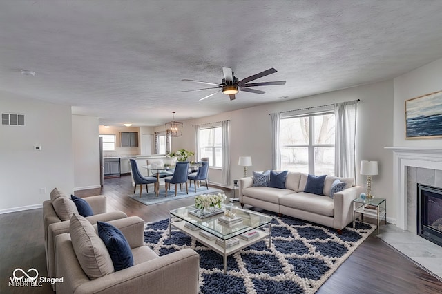 living room with a tile fireplace, dark hardwood / wood-style floors, and a healthy amount of sunlight