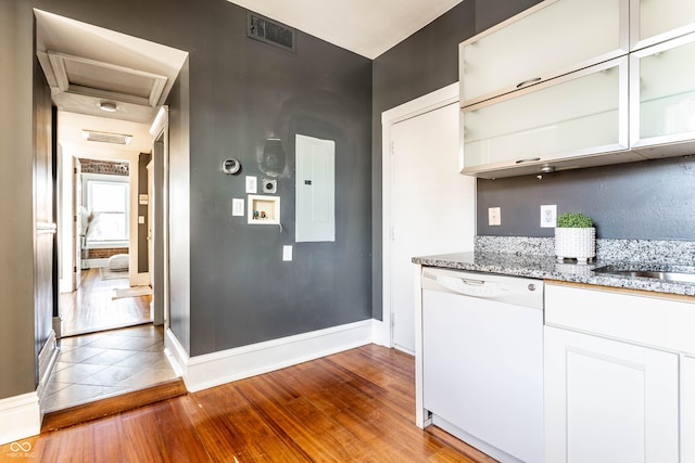 kitchen with hardwood / wood-style flooring, white dishwasher, light stone countertops, electric panel, and white cabinets