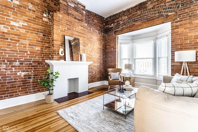 unfurnished living room with brick wall and hardwood / wood-style floors