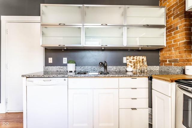 kitchen with white cabinets, backsplash, dishwasher, and sink