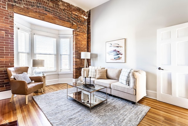 living room featuring brick wall and hardwood / wood-style floors