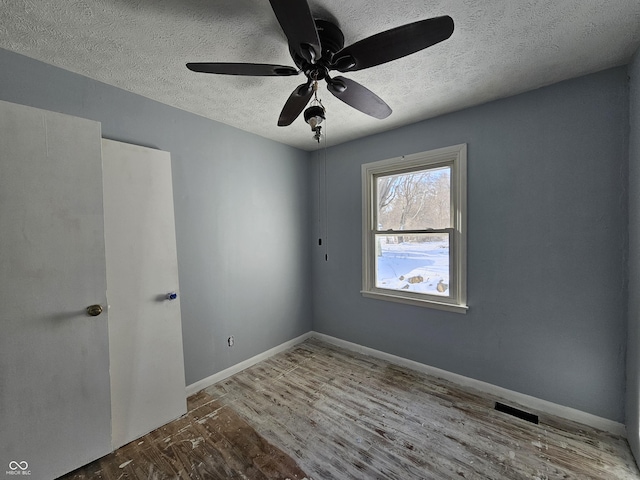 spare room featuring a textured ceiling, ceiling fan, and wood-type flooring