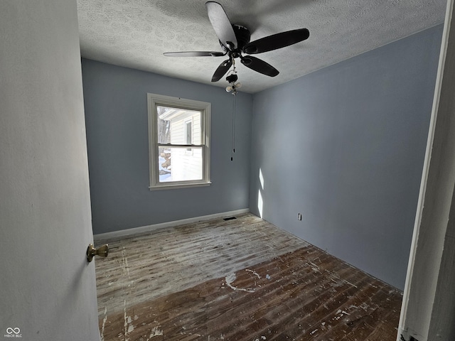 spare room featuring ceiling fan, dark hardwood / wood-style flooring, and a textured ceiling