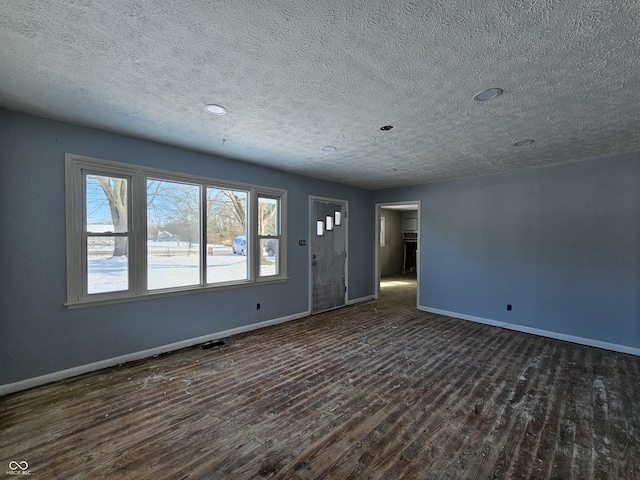 unfurnished room featuring a textured ceiling and dark hardwood / wood-style flooring