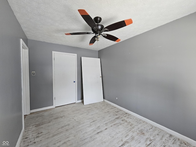 unfurnished bedroom with ceiling fan, a textured ceiling, and light hardwood / wood-style flooring