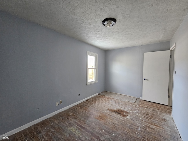 unfurnished room with a textured ceiling and hardwood / wood-style floors