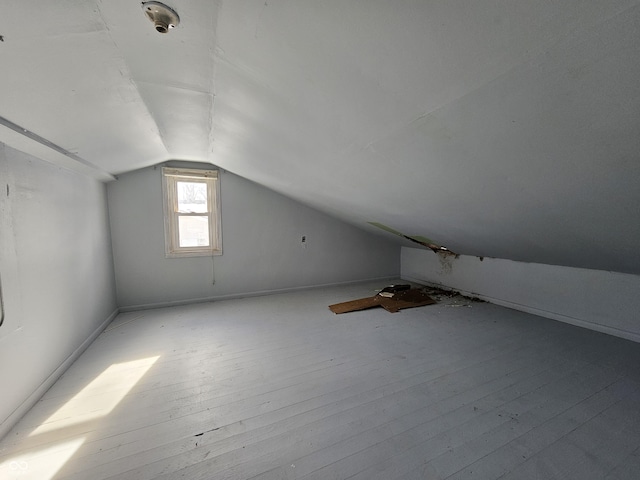 additional living space with light hardwood / wood-style floors and vaulted ceiling