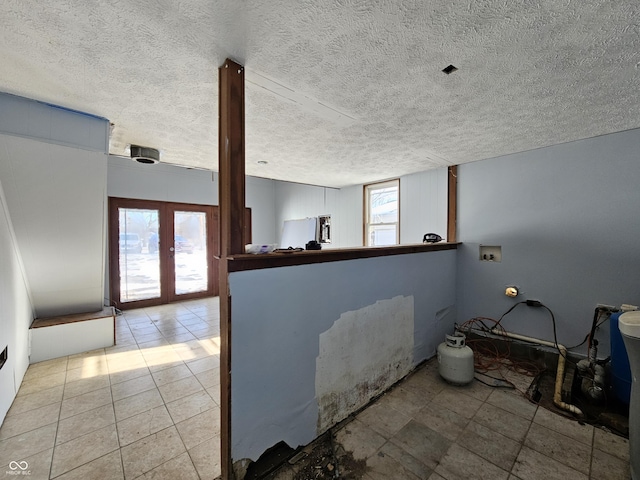 interior space featuring french doors and a textured ceiling