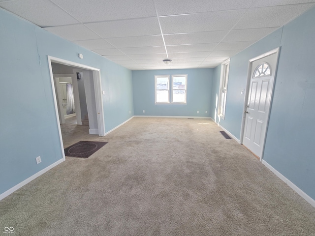 carpeted spare room featuring a drop ceiling