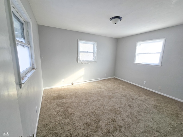 carpeted empty room featuring plenty of natural light and a baseboard radiator