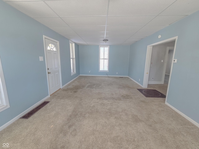 carpeted spare room featuring a drop ceiling