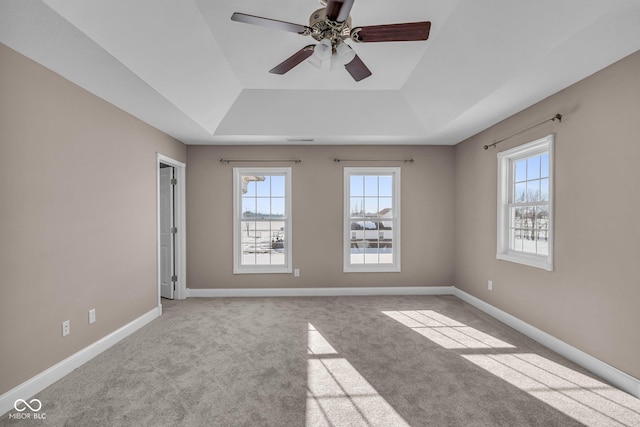 carpeted spare room featuring ceiling fan and a tray ceiling