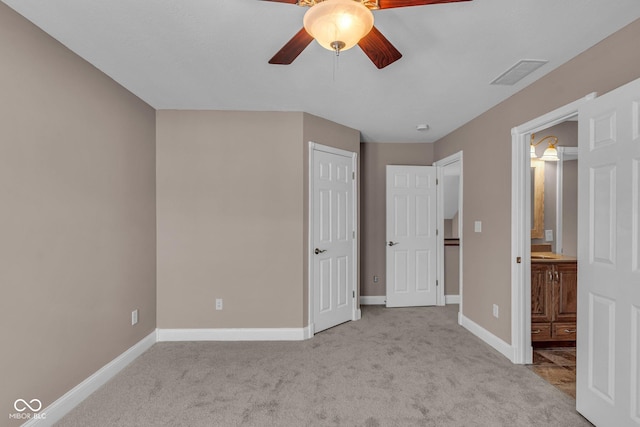 unfurnished bedroom featuring ceiling fan, connected bathroom, and light colored carpet