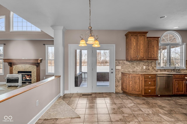 kitchen featuring an inviting chandelier, backsplash, decorative light fixtures, dishwasher, and sink