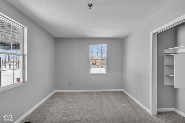 unfurnished bedroom with a textured ceiling and carpet flooring