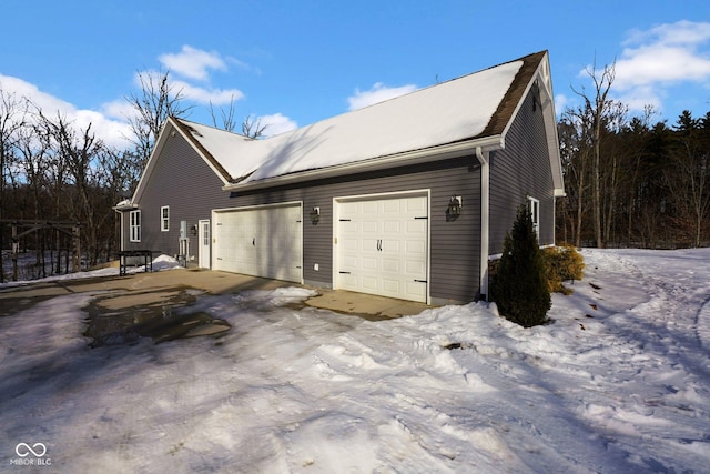 view of snow covered exterior with a garage