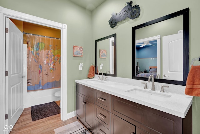 full bathroom featuring toilet, hardwood / wood-style flooring, ceiling fan, shower / tub combo, and vanity