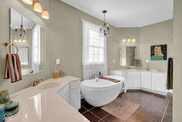 bathroom featuring tile patterned floors, vanity, a bath, and an inviting chandelier